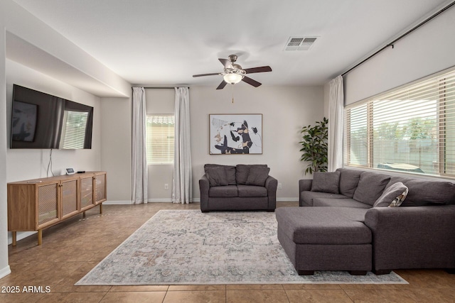 living room with a healthy amount of sunlight, ceiling fan, visible vents, and baseboards