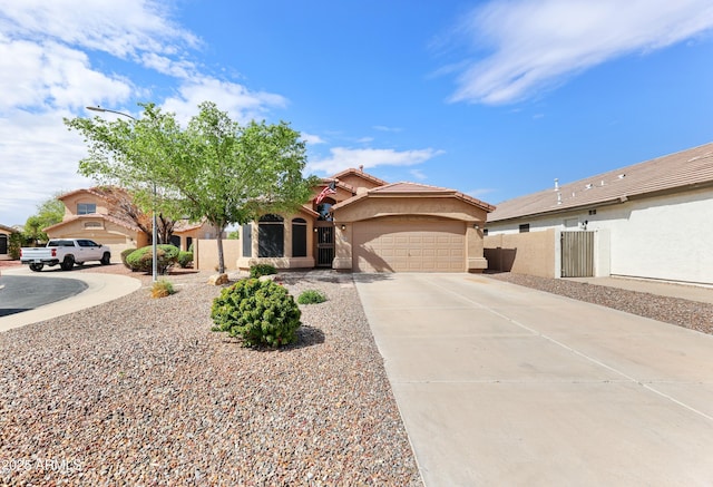 view of front of home with stucco siding, a tile roof, fence, concrete driveway, and an attached garage