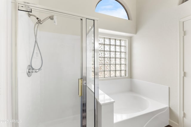 full bathroom featuring a garden tub and a stall shower