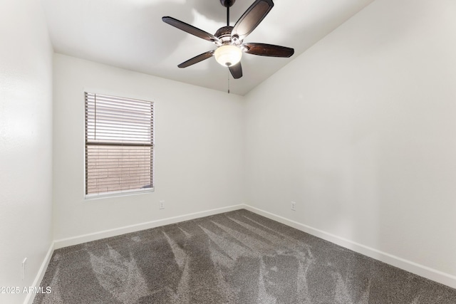 spare room with a ceiling fan, dark colored carpet, and baseboards