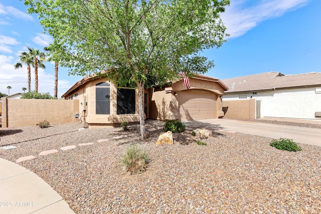 view of front of property with concrete driveway, an attached garage, fence, and stucco siding