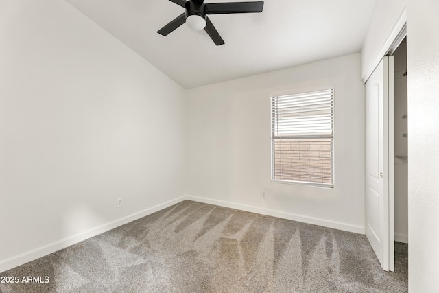 unfurnished bedroom featuring a closet, baseboards, carpet flooring, and vaulted ceiling