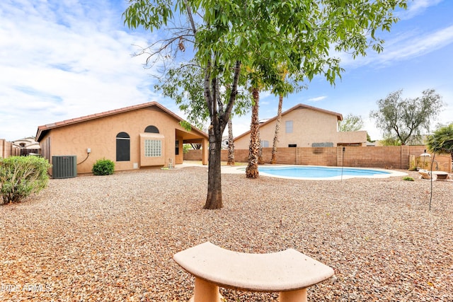 view of yard with a patio, central AC unit, a fenced in pool, and a fenced backyard