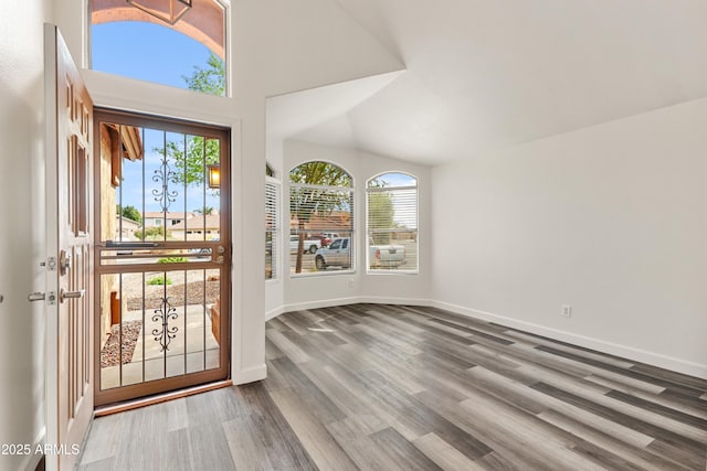 entrance foyer with baseboards, high vaulted ceiling, and wood finished floors