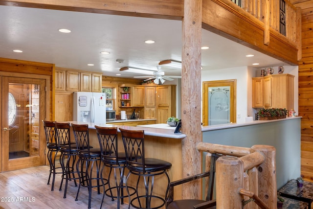 2 Acr 1027 Rd, Greer, AZ 85927 - kitchen featuring white fridge with ice dispenser, recessed lighting, light countertops, light wood-style flooring, and a breakfast bar