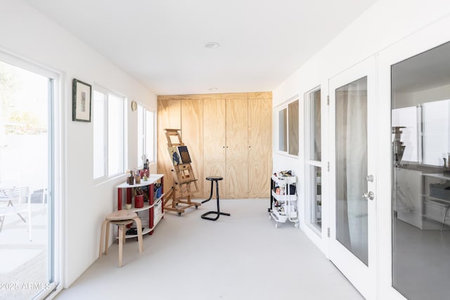 sitting room featuring concrete flooring and french doors