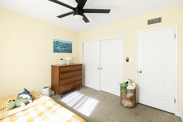 carpeted bedroom featuring ceiling fan and a closet