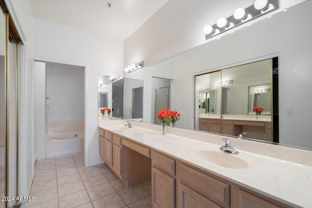 bathroom with tile patterned floors, a tub to relax in, and vanity