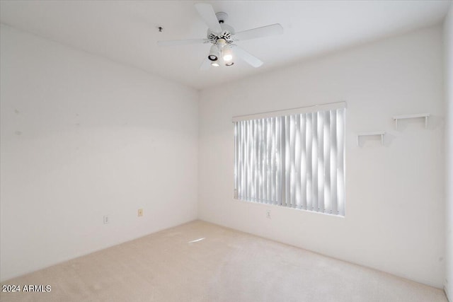 carpeted spare room featuring ceiling fan and a healthy amount of sunlight