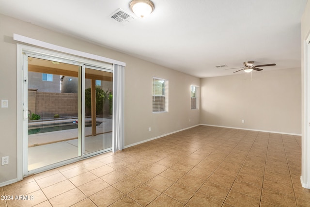 tiled spare room with ceiling fan