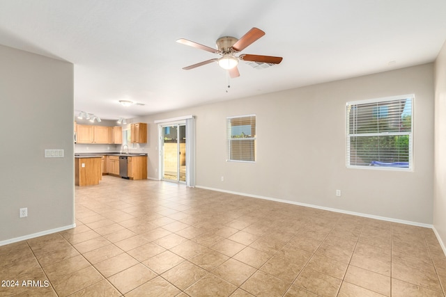 unfurnished living room featuring a wealth of natural light, ceiling fan, and light tile patterned floors