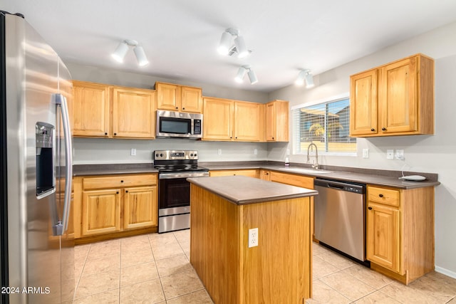 kitchen featuring light tile patterned flooring, stainless steel appliances, sink, and a kitchen island