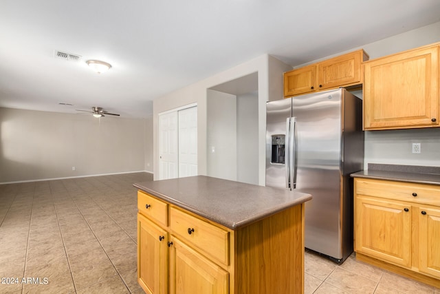 kitchen with ceiling fan, a kitchen island, stainless steel fridge with ice dispenser, and light tile patterned flooring