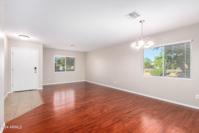 unfurnished room featuring hardwood / wood-style floors and a notable chandelier