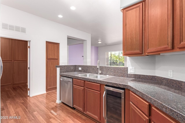 kitchen featuring wine cooler, sink, stainless steel dishwasher, and light hardwood / wood-style floors