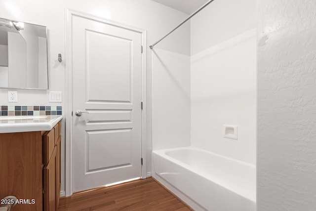 bathroom with vanity, hardwood / wood-style flooring, and shower / bathing tub combination