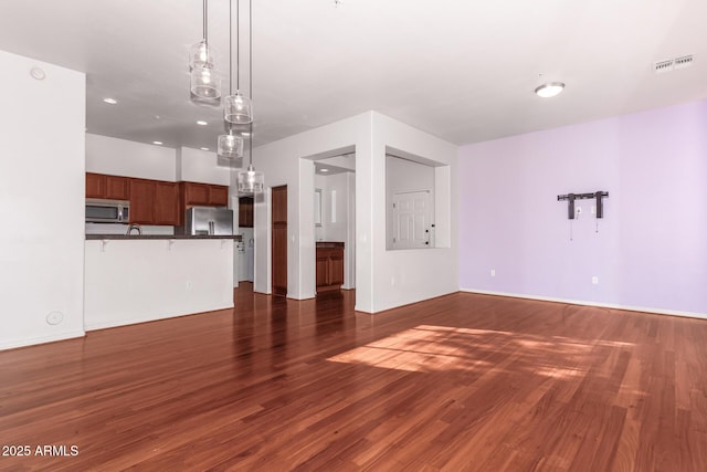 unfurnished living room with dark wood-type flooring