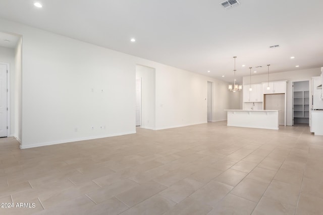 unfurnished living room featuring an inviting chandelier