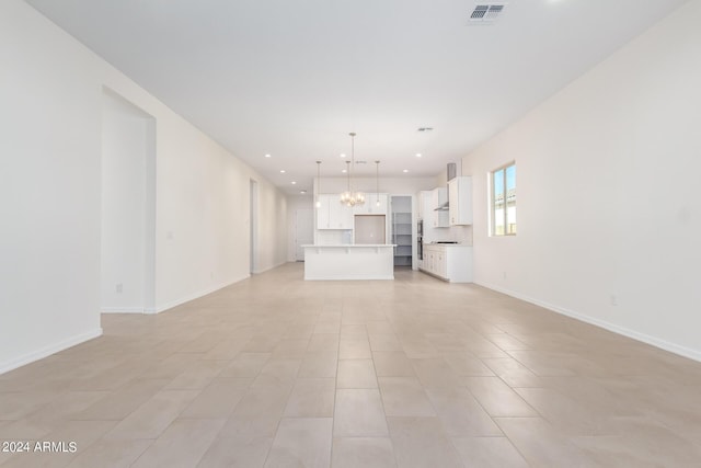 unfurnished living room featuring an inviting chandelier