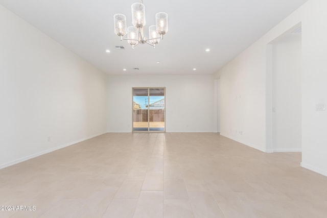 spare room featuring light tile patterned floors and a notable chandelier