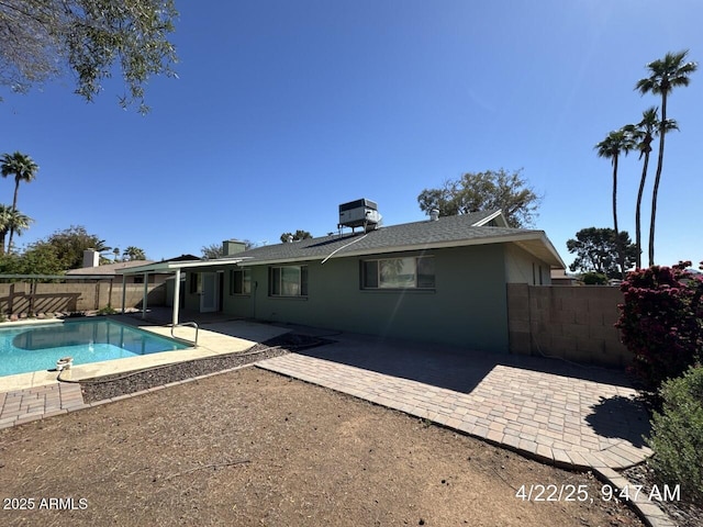 rear view of property with cooling unit, a fenced in pool, a fenced backyard, and a patio area