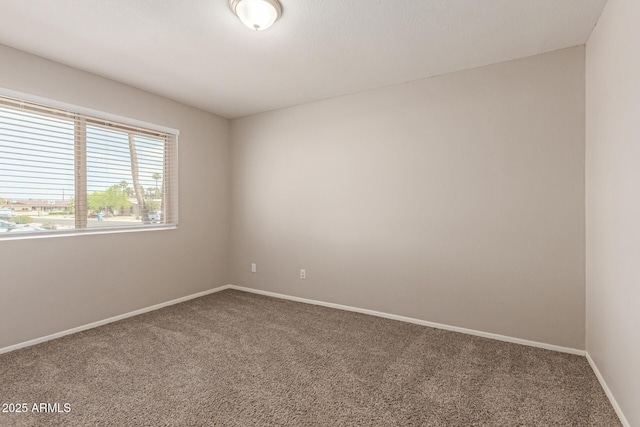 empty room featuring carpet flooring and baseboards