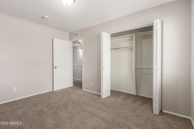 unfurnished bedroom with baseboards, visible vents, carpet floors, and a closet