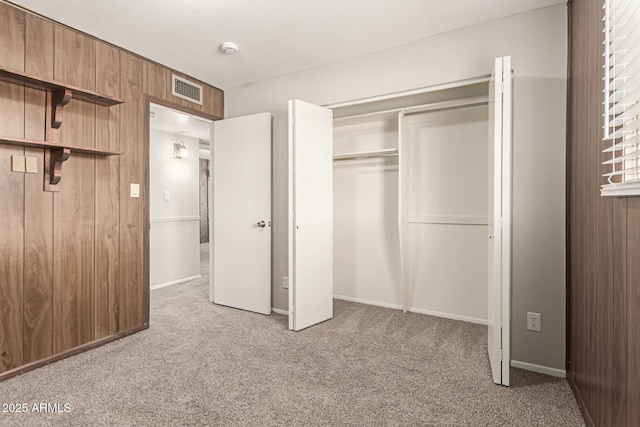 unfurnished bedroom with visible vents, a closet, and carpet flooring