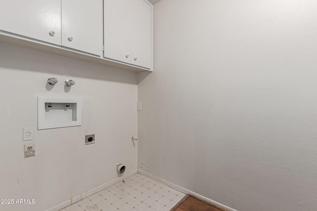 clothes washing area with hookup for an electric dryer, cabinet space, washer hookup, and baseboards
