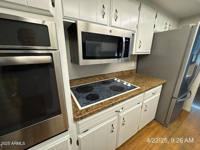 kitchen with white cabinets, wood finished floors, and stainless steel appliances
