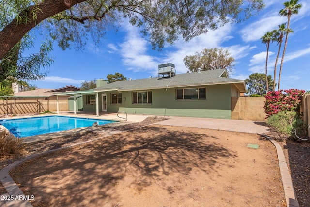 rear view of house with a patio, a fenced in pool, a shingled roof, and a fenced backyard