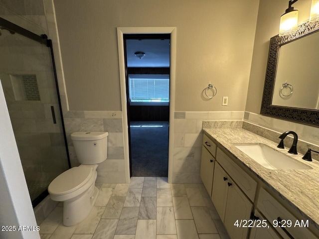 full bath featuring tile walls, a wainscoted wall, and vanity