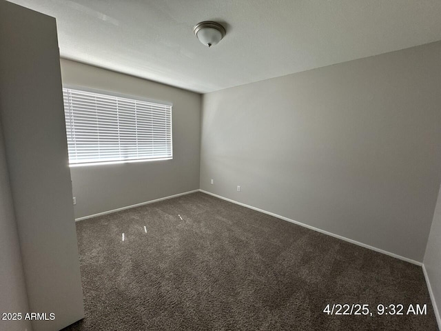 unfurnished room with carpet and baseboards