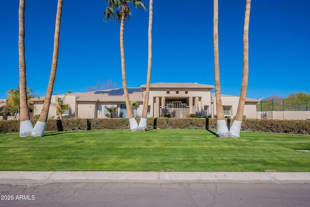 mediterranean / spanish-style home featuring a front yard, fence, and stucco siding