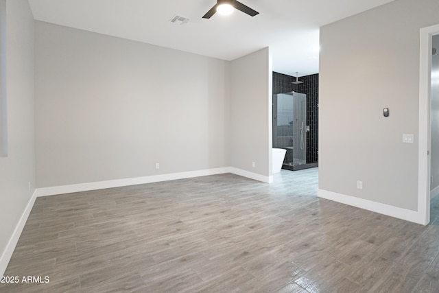 unfurnished room featuring visible vents, baseboards, ceiling fan, and wood finished floors