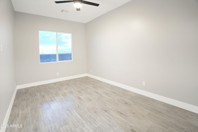 empty room featuring visible vents, baseboards, light wood-style floors, and a ceiling fan