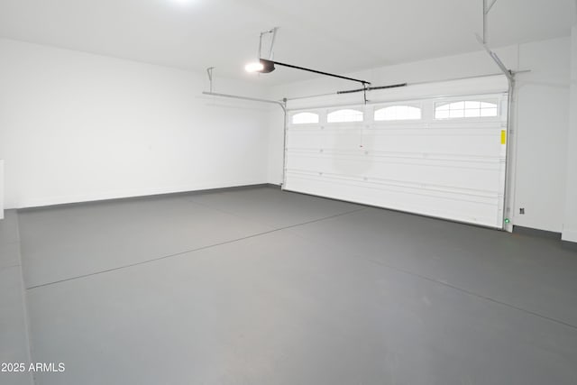 garage featuring a garage door opener and baseboards