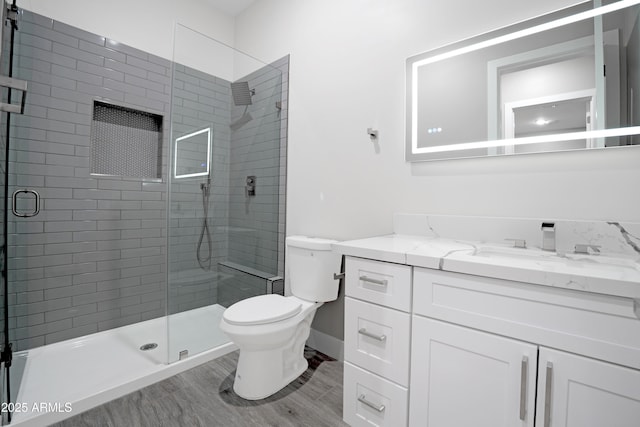 full bathroom featuring vanity, toilet, wood finished floors, and a shower stall