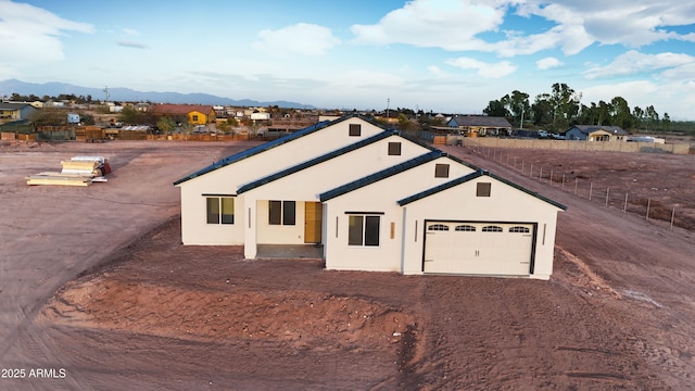 view of front of property with stucco siding, driveway, a garage, and a mountain view