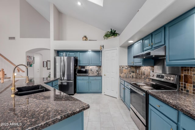 kitchen with under cabinet range hood, stainless steel appliances, blue cabinets, and a sink