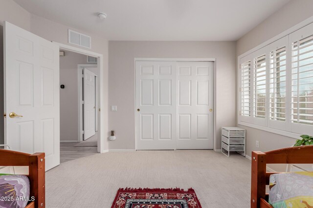 bedroom featuring a closet, visible vents, carpet flooring, and baseboards