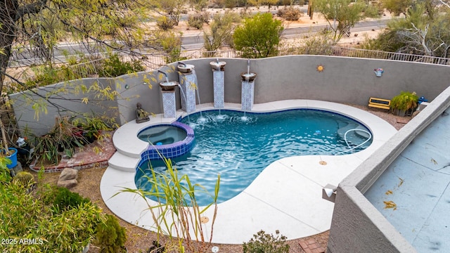 view of swimming pool with a pool with connected hot tub and a fenced backyard