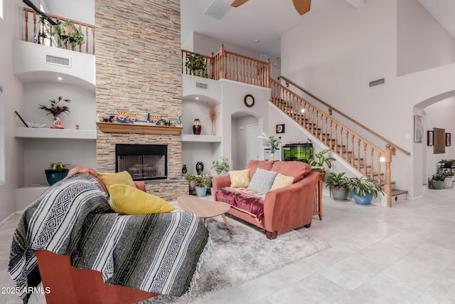 living room featuring a fireplace, arched walkways, and visible vents