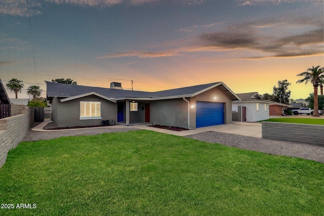 ranch-style house featuring concrete driveway, a lawn, an attached garage, fence, and stucco siding