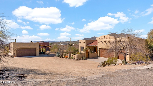 view of front facade with a tiled roof, driveway, and stucco siding