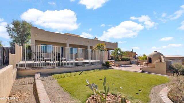 back of property with a patio area, stucco siding, and fence