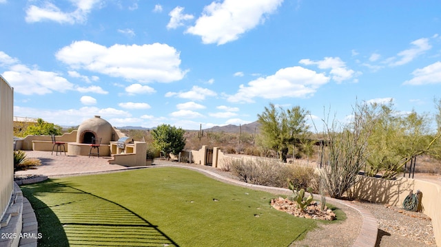 view of yard featuring a mountain view, a patio, fence private yard, and an outdoor fireplace