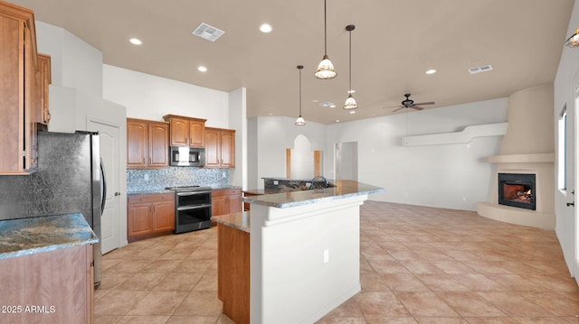 kitchen featuring tasteful backsplash, a fireplace, visible vents, and appliances with stainless steel finishes