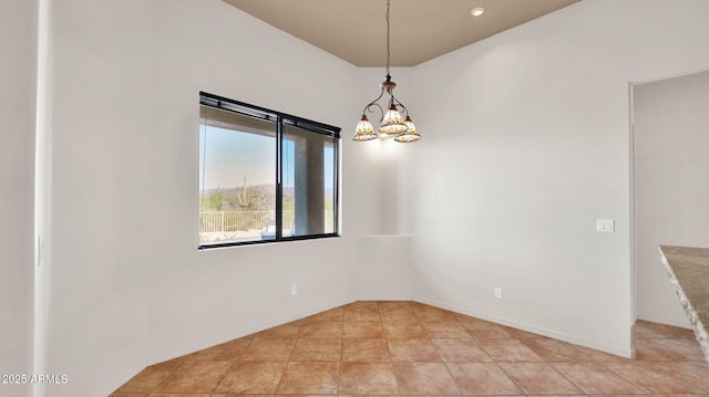 spare room featuring light tile patterned floors, a notable chandelier, and baseboards