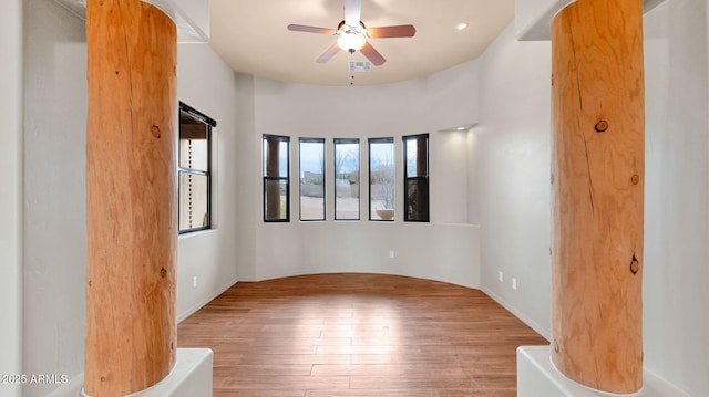 unfurnished room with visible vents, baseboards, a ceiling fan, and hardwood / wood-style flooring